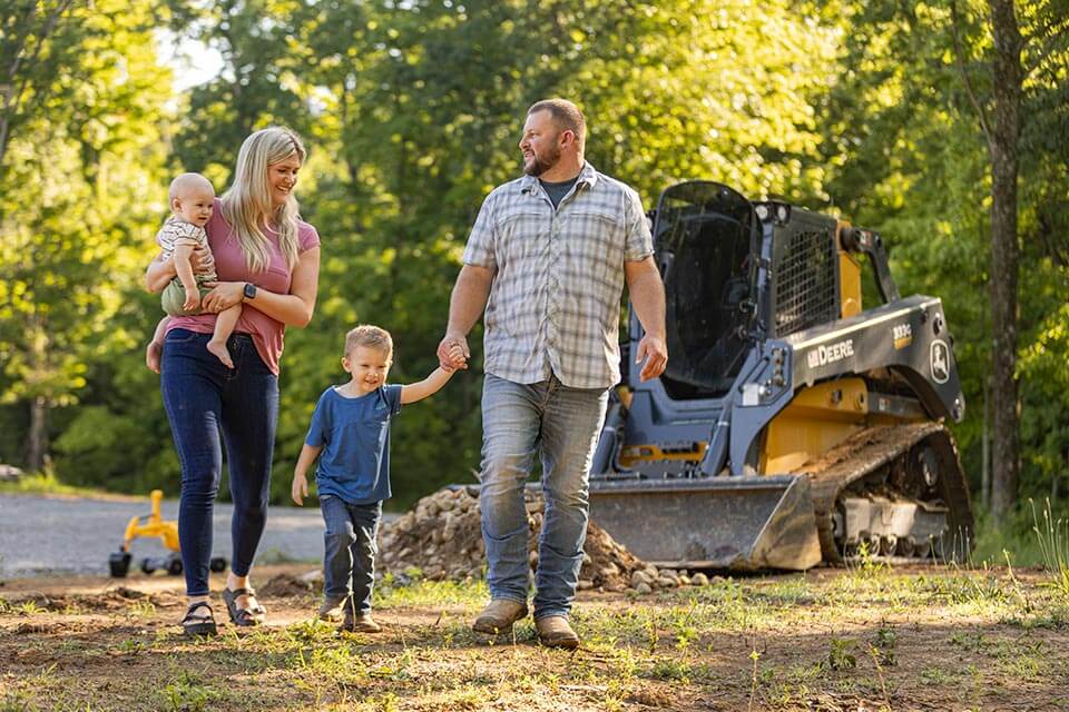 Ryan and Brittany Richmond walking with their children on their land.