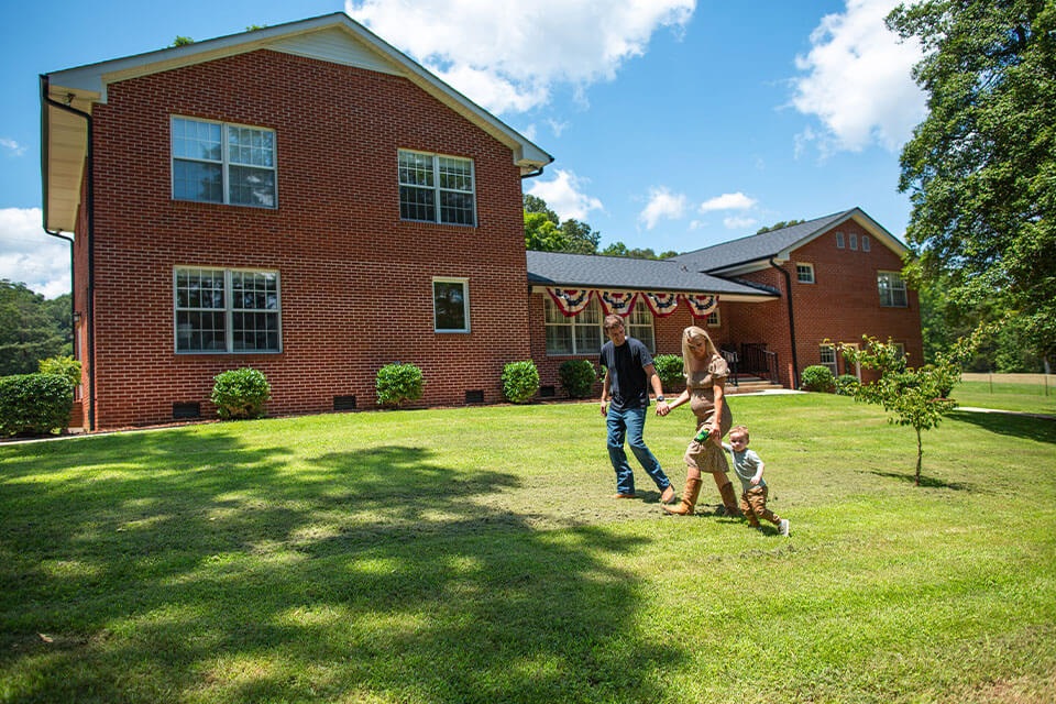 Family walk next to house financed through Rural 1st home loan in Tennessee.